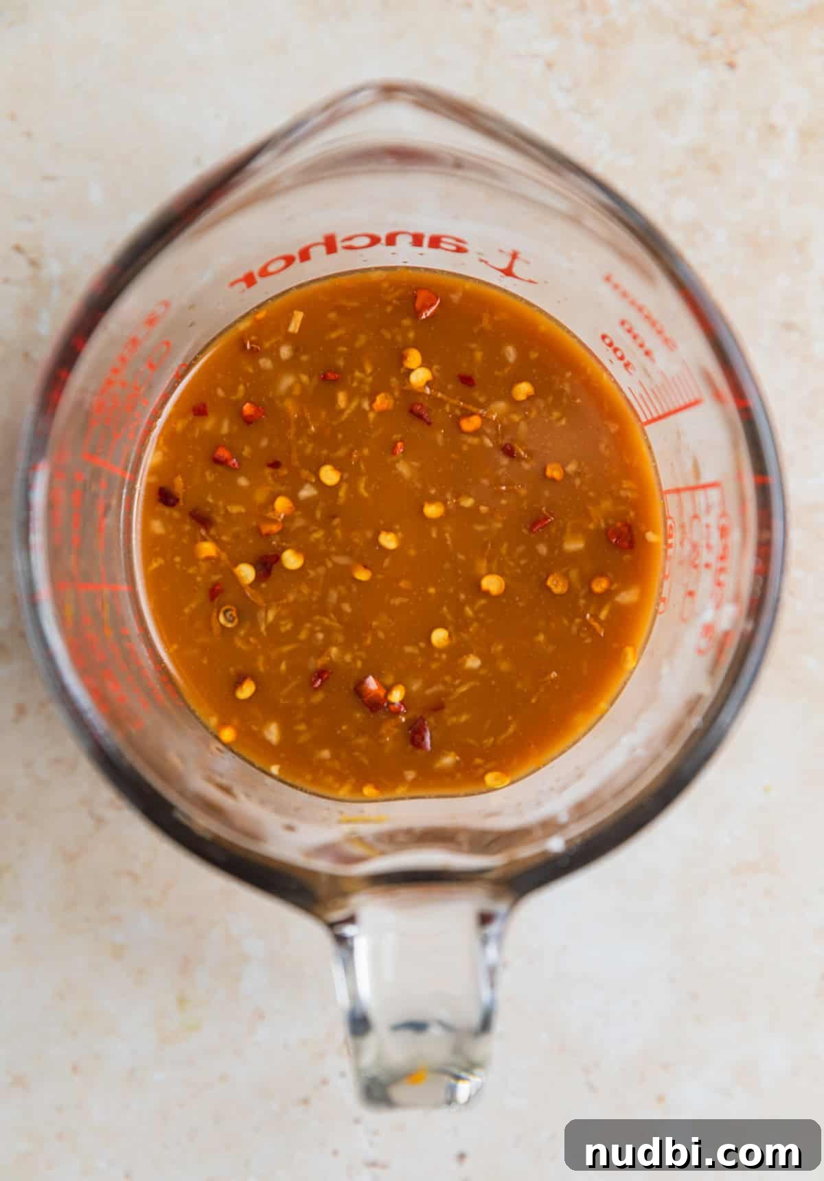 Whisked teriyaki sauce in glass measuring cup.
