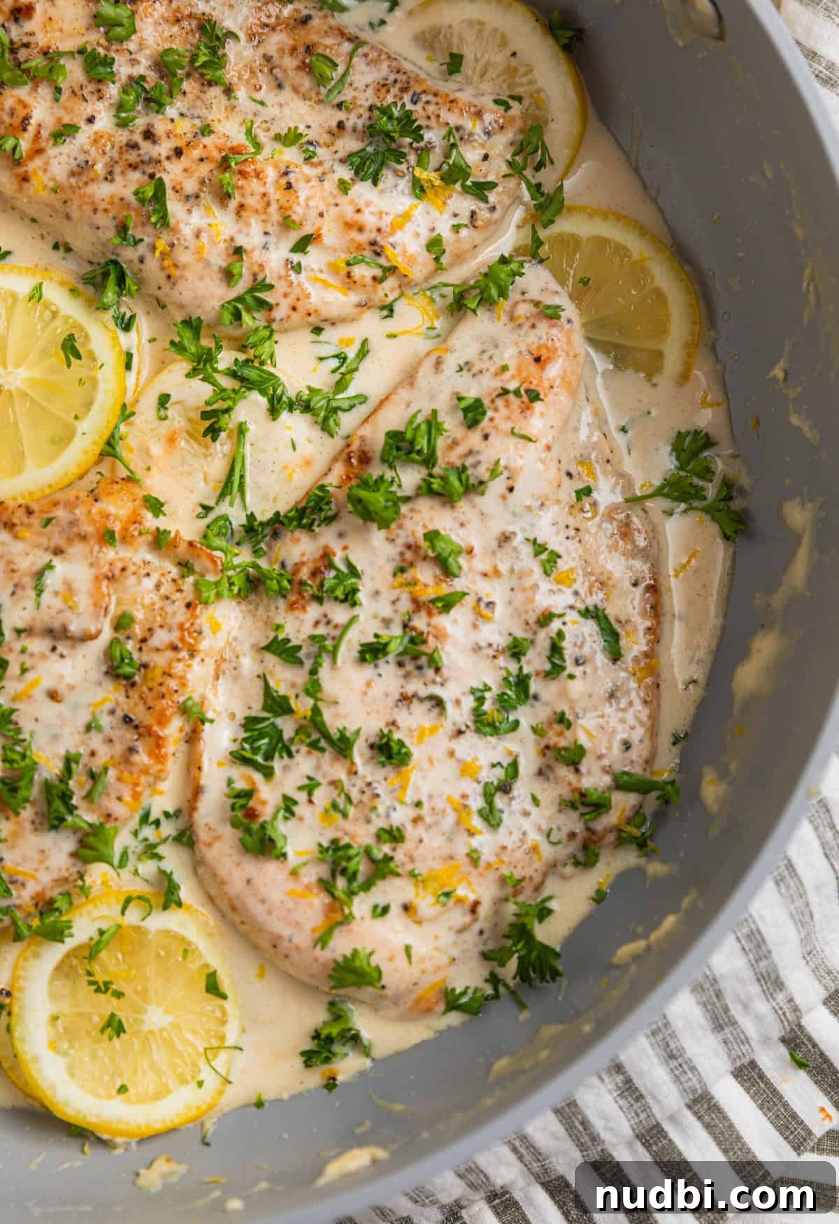 Creamy Skillet Lemon Chicken Recipe for Quick Weeknight Meals 2 Skillet with creamy lemon chicken topped with chopped parsley.