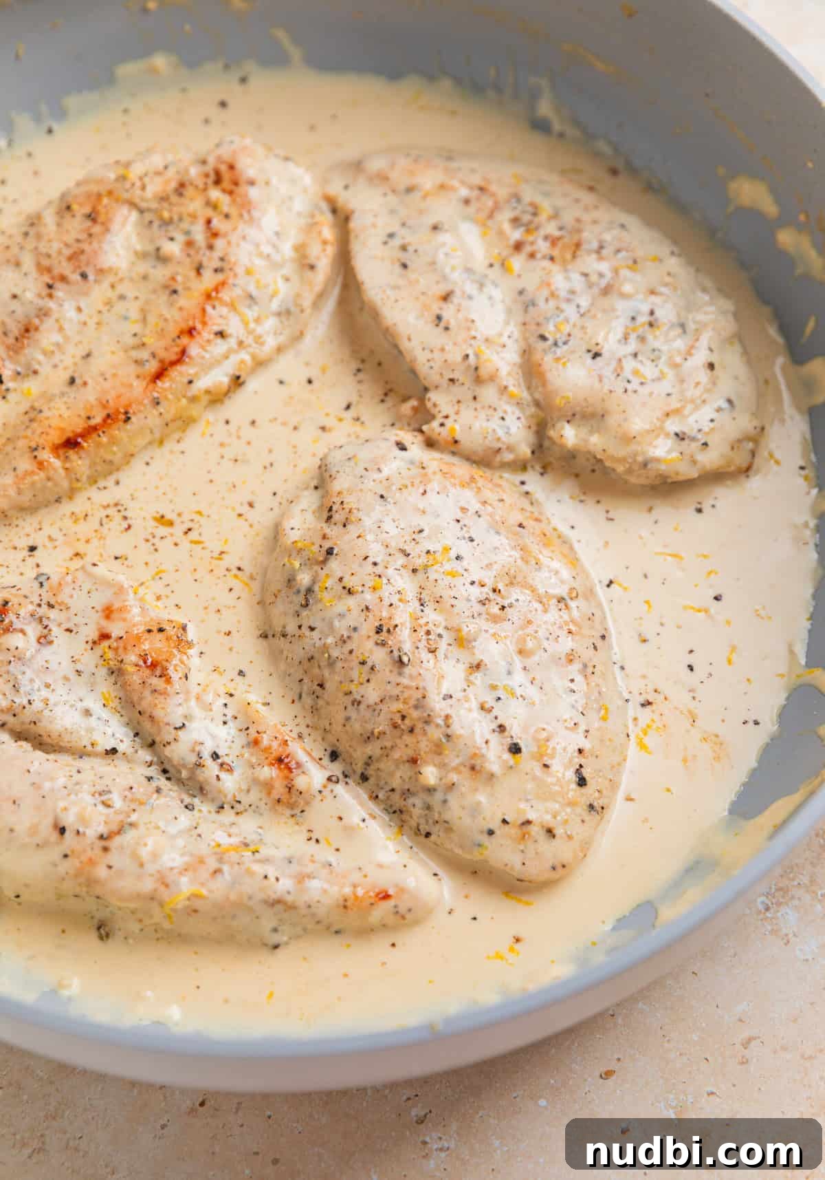 Creamy Skillet Lemon Chicken Recipe for Quick Weeknight Meals 7 Chicken breasts in creamy lemon sauce in skillet.