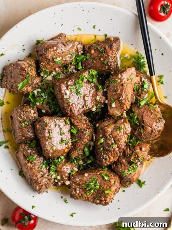 Cilantro-Lime Flat Iron Steak Fajitas Recipe 12 White plate with air fryer steak bites in lemon garlic butter sauce with fresh parsley over top.