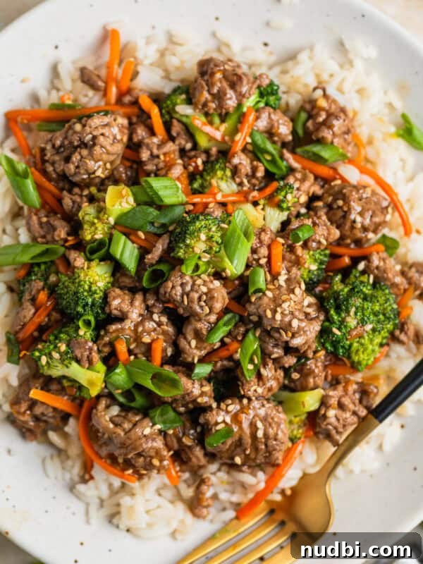 Cilantro-Lime Flat Iron Steak Fajitas Recipe 13 White plate with beef teriyaki served over white rice and topped with chopped green onions and toasted sesame seeds.
