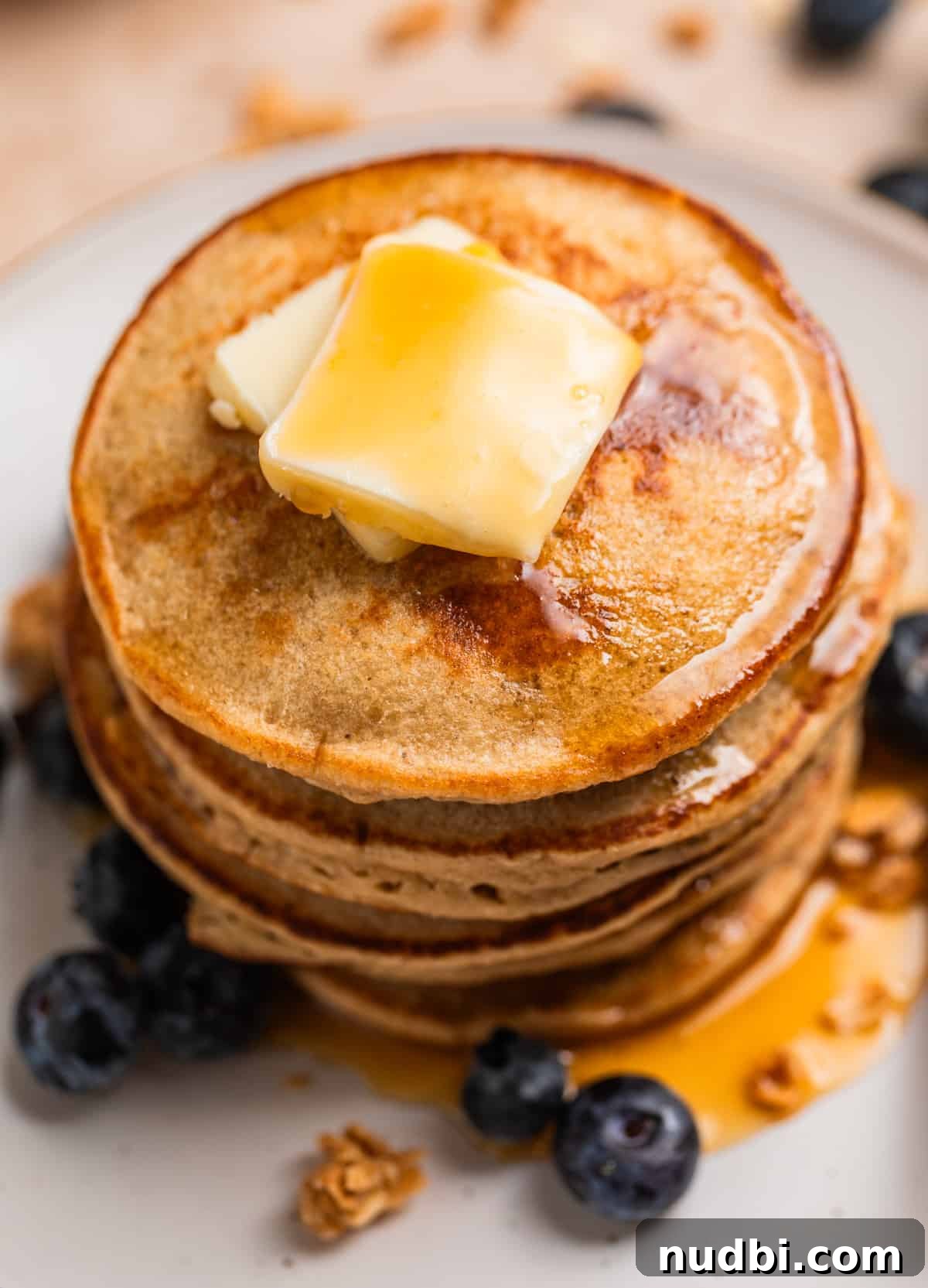 Fluffy Banana Oat Blender Pancakes in Minutes 2 Stack of banana oatmeal blender pancakes on plate with butter and syrup.