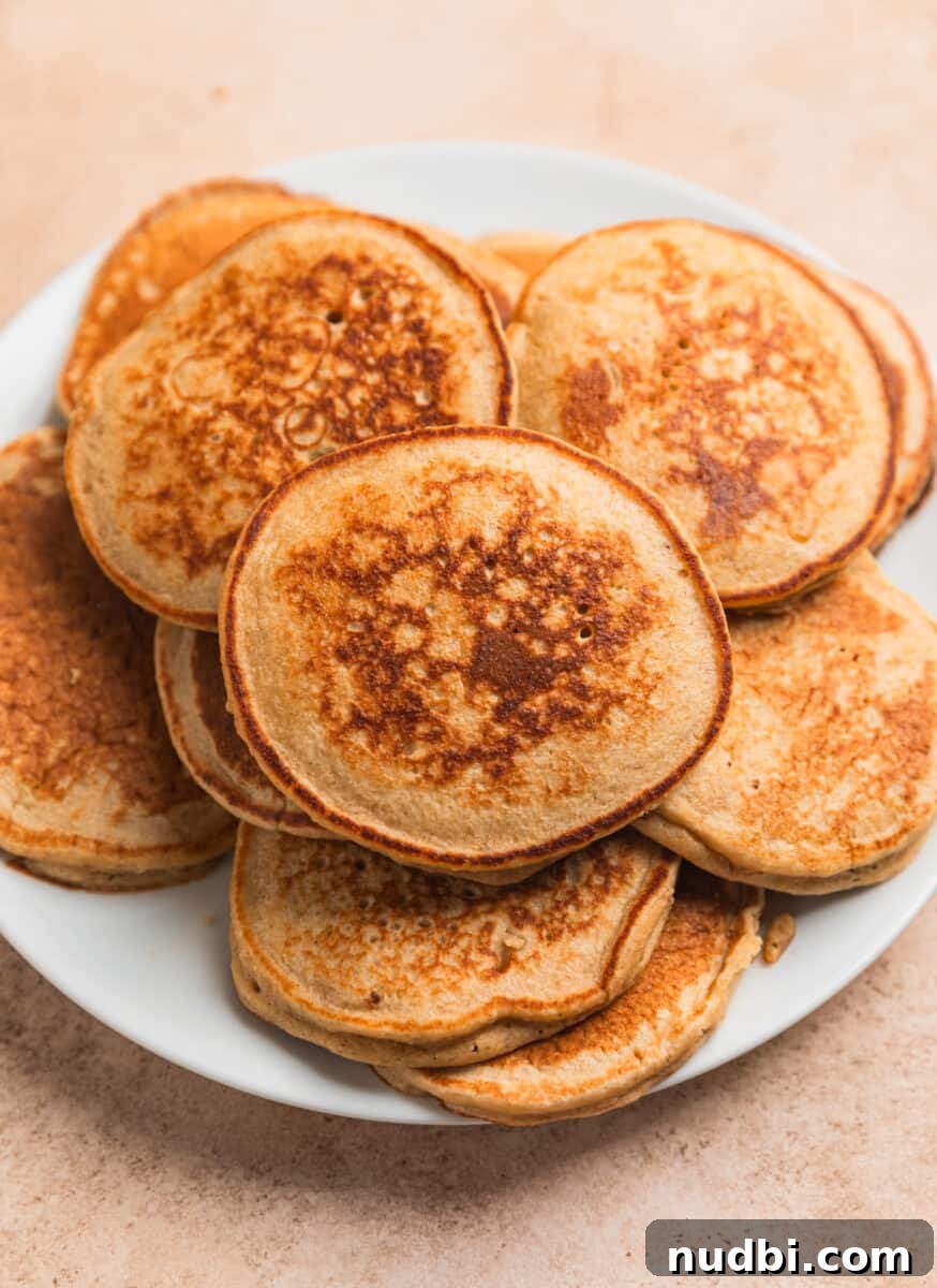 Fluffy Banana Oat Blender Pancakes in Minutes 8 Banana oat pancakes cooked and arranged on plate.