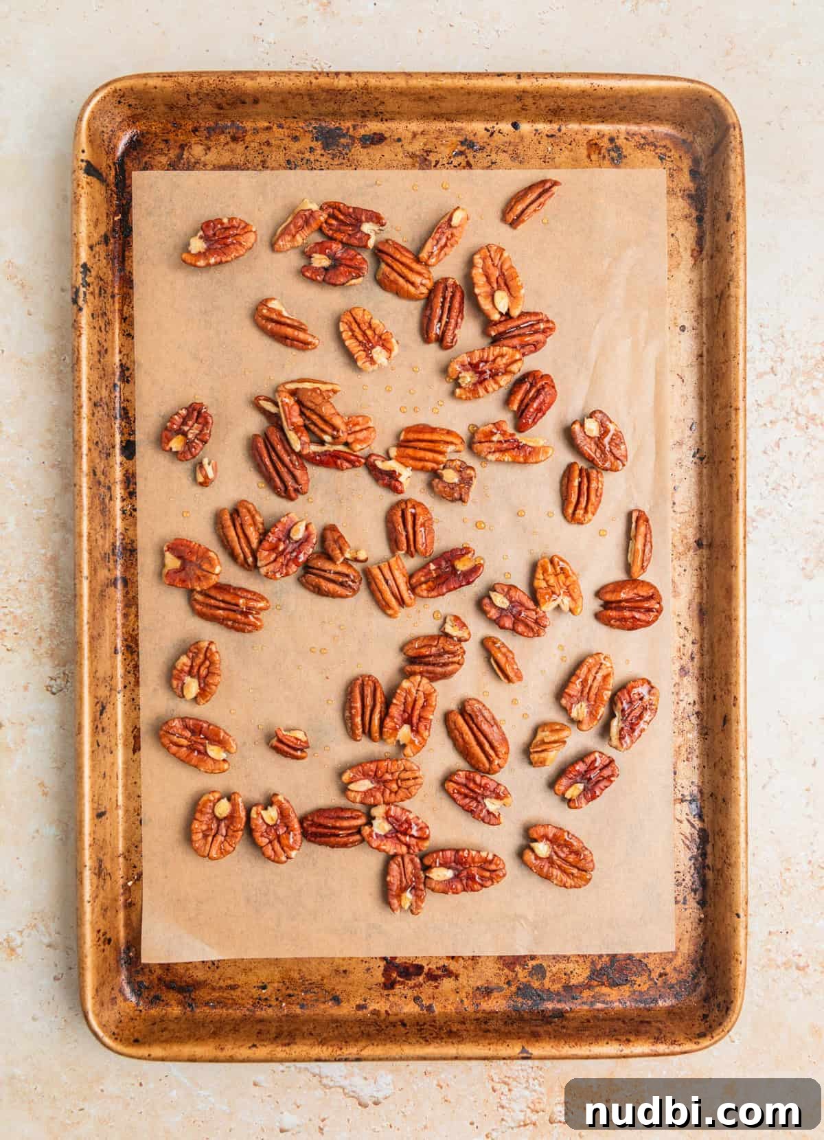 Crisp Apple and Arugula Salad with Honey Dijon Dressing 4 Maple pecans arranged evenly on a parchment lined baking sheet.