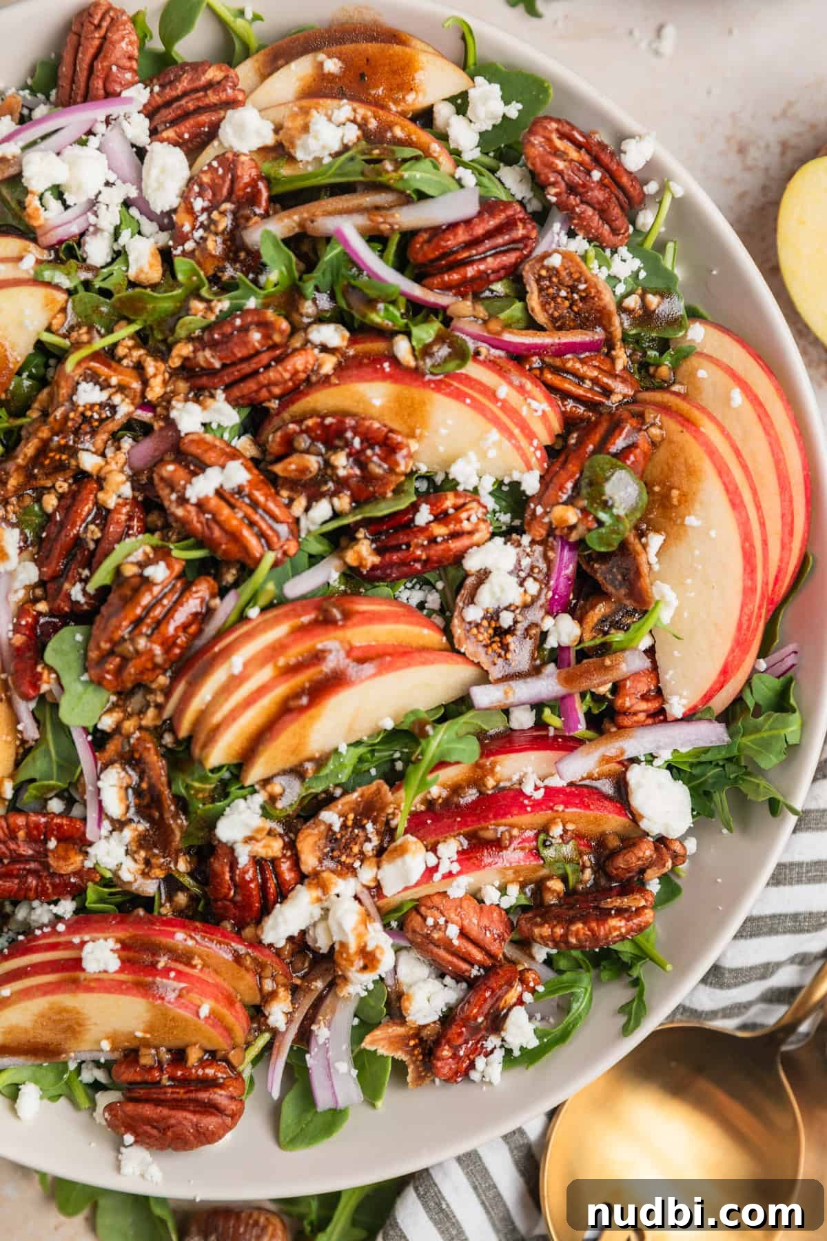 Crisp Apple and Arugula Salad with Honey Dijon Dressing 9 Overhead view of dish with salad bowl including sliced apples, maple pecans, and more.