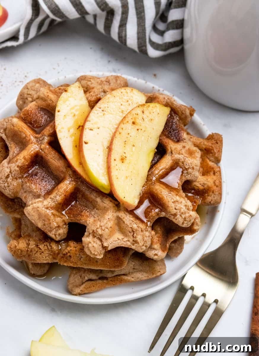 Cinnamon Apple Vegan Waffles — Fluffy Plant-Based Breakfast 2 Vegan waffles with syrup and sliced apple.