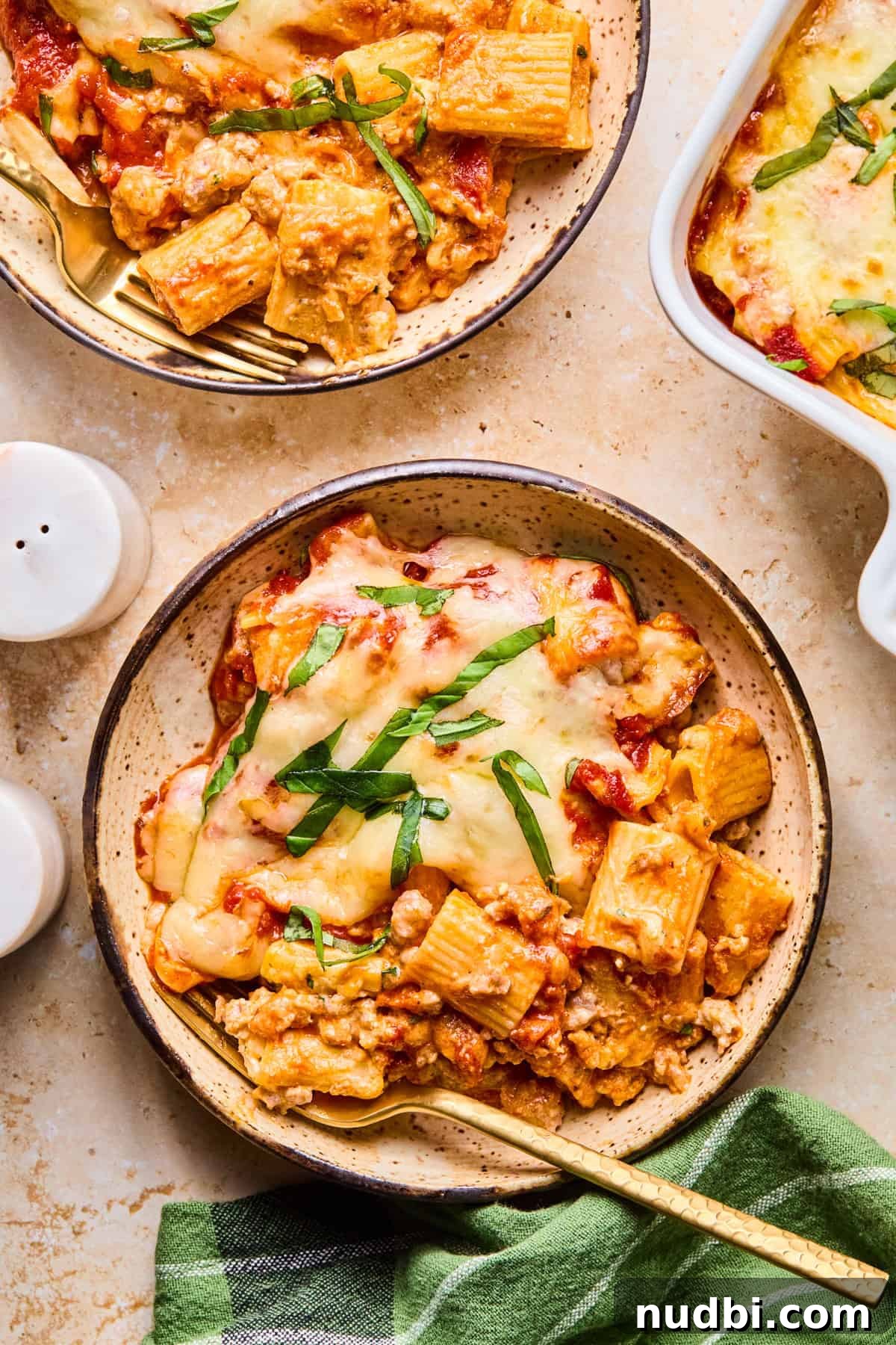 Cheesy Italian Sausage Pasta Bake with Roasted Tomatoes 15 Bowl of baked pasta with fresh basil and melty mozzarella on top.