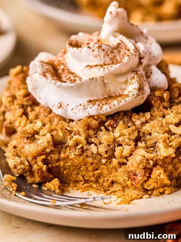 No-Bake Pumpkin Cheesecake Bars Recipe — Creamy Autumn Dessert 13 Slice of pumpkin pie crumble on plate with whipped cream and cinnamon over top and a fork on the plate beside it.