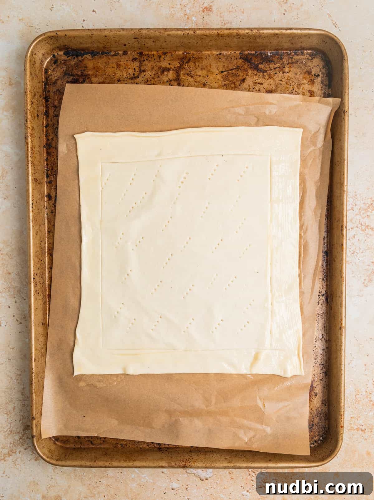 Crisp Puff Pastry Apple Tart Recipe for Homemade Dessert 5 Sheet of puff pastry with edges scored laying on parchment lined sheet pan.