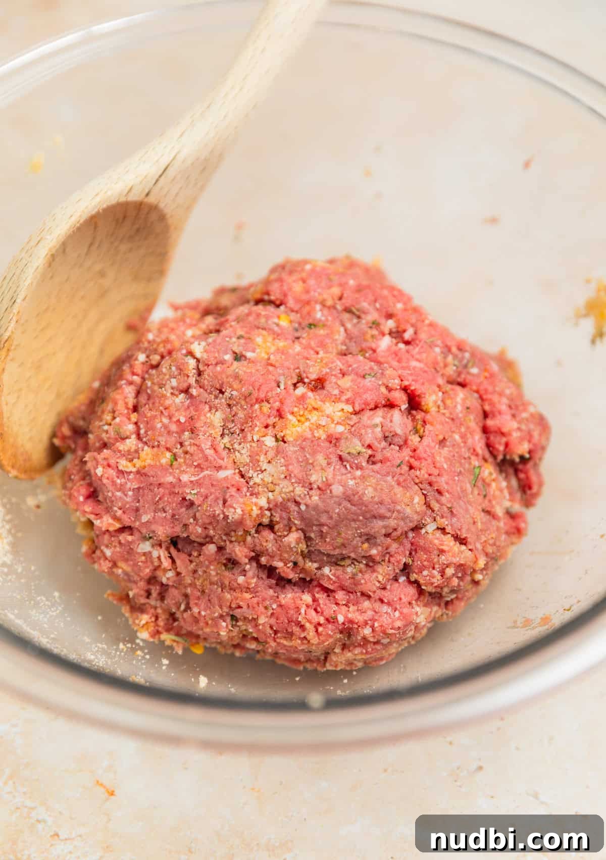 Hearty Vegetable and Meatball Soup Recipe for Cozy Meals 4 Meatball mixture prepared in bowl with wooden spoon.