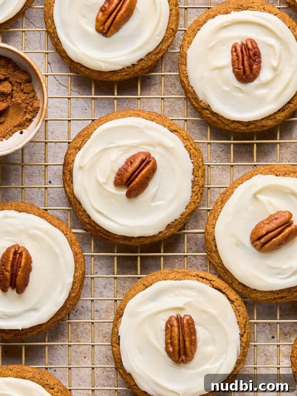 Nutella Thumbprint Cookies Recipe — Gooey Chocolate Hazelnut Treats 16 Iced molasses cookies with pecan half on top arranged on cooling rack.