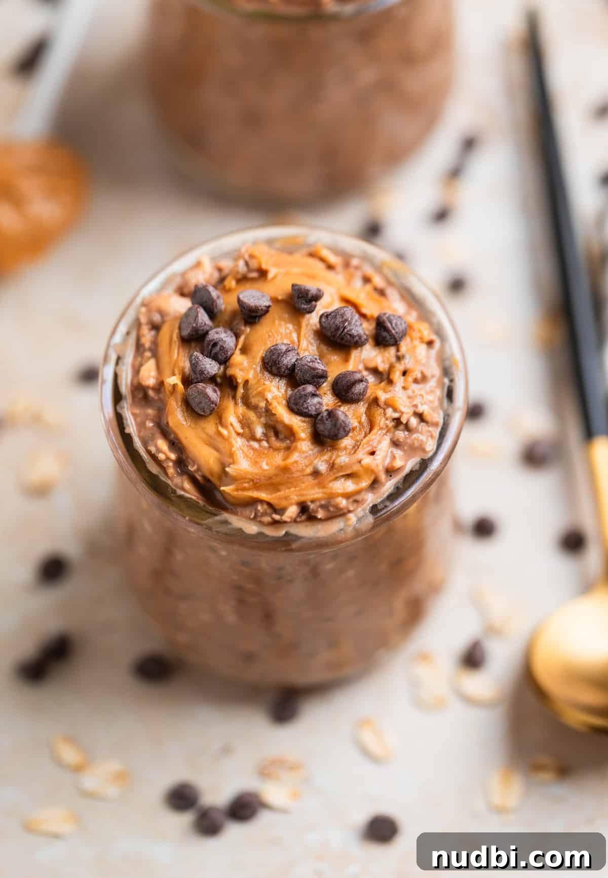 Chocolate Peanut Butter Overnight Oats Recipe for Creamy Breakfast 4 Glass jar with peanut butter topped chocolate overnight oats topped with mini chocolate chips.