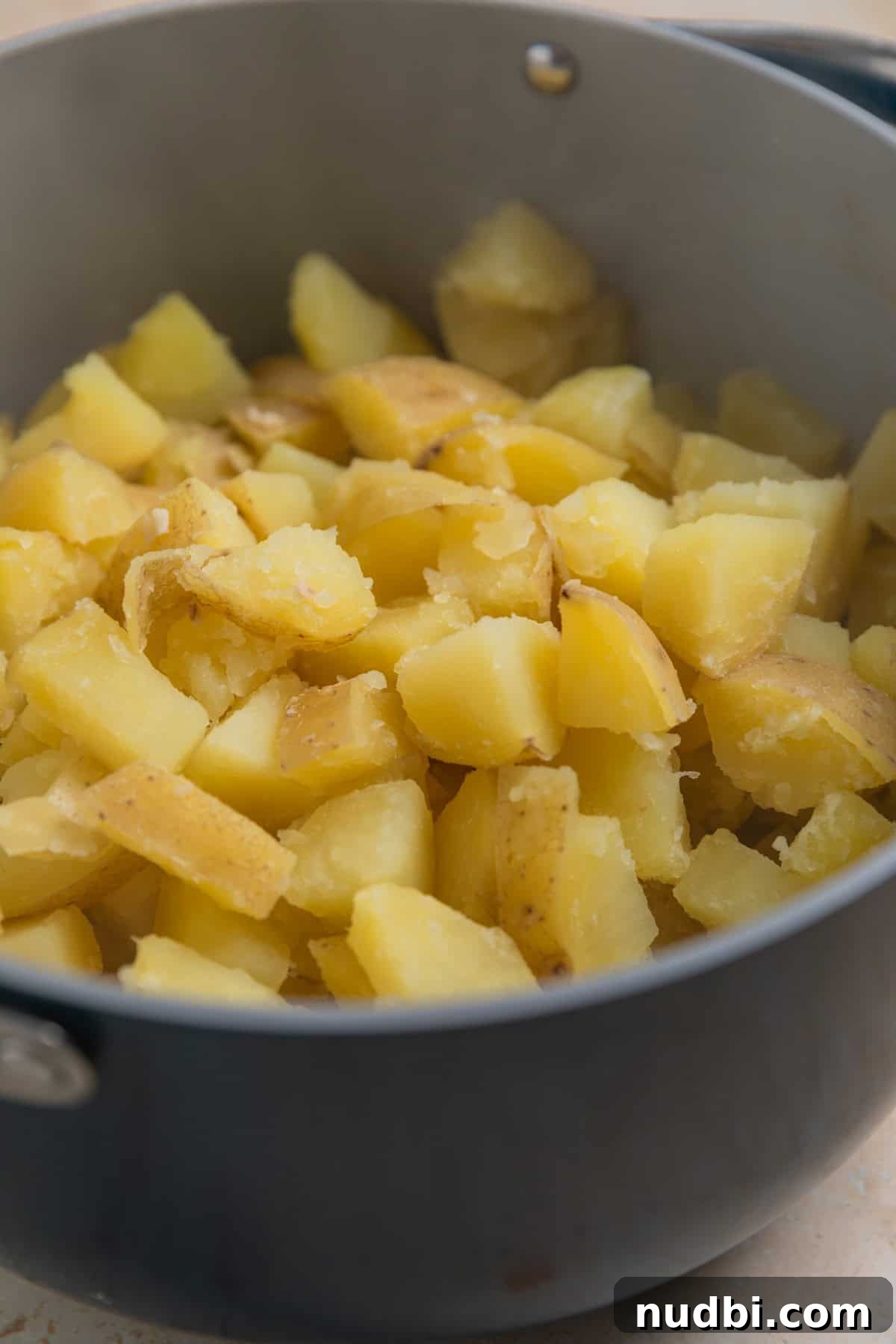 Creamy Boursin Mashed Potatoes Recipe for Garlic-Herb Flavor 4 Boiled potatoes in pot before being mashed.