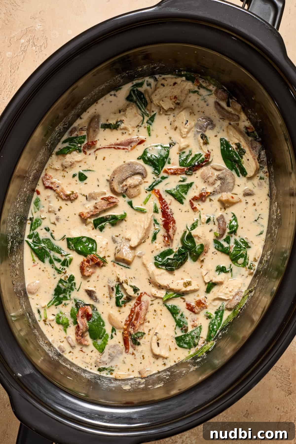 Creamy Slow Cooker Chicken Pasta Recipe 11 Spinach and basil added to crockpot with chicken.
