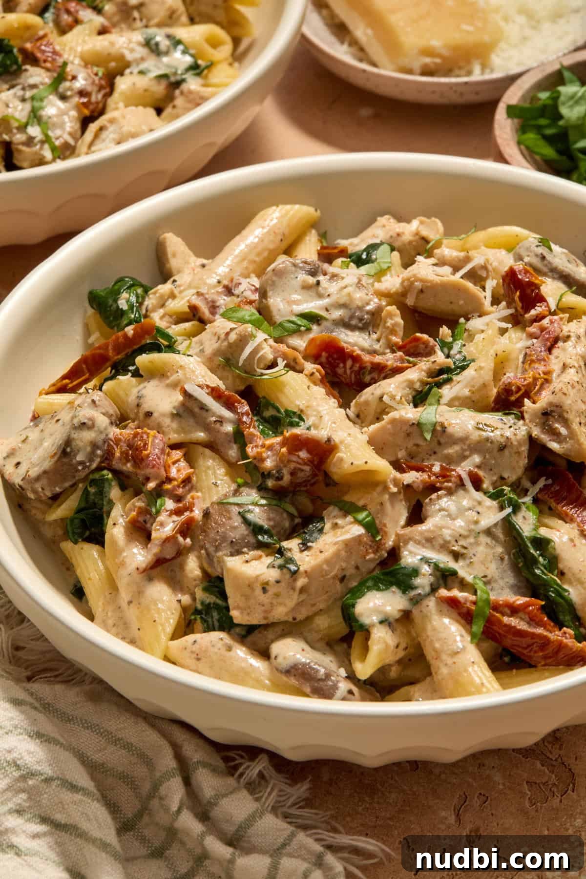 Creamy Slow Cooker Chicken Pasta Recipe 13 Bowl of creamy slow cooker chicken pasta topped with fresh basil and parmesan.