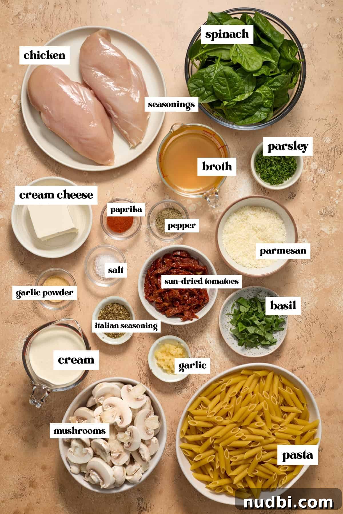 Creamy Slow Cooker Chicken Pasta Recipe 4 Chicken breast, spinach, mushrooms, parmesan and other labeled ingredients on surface.