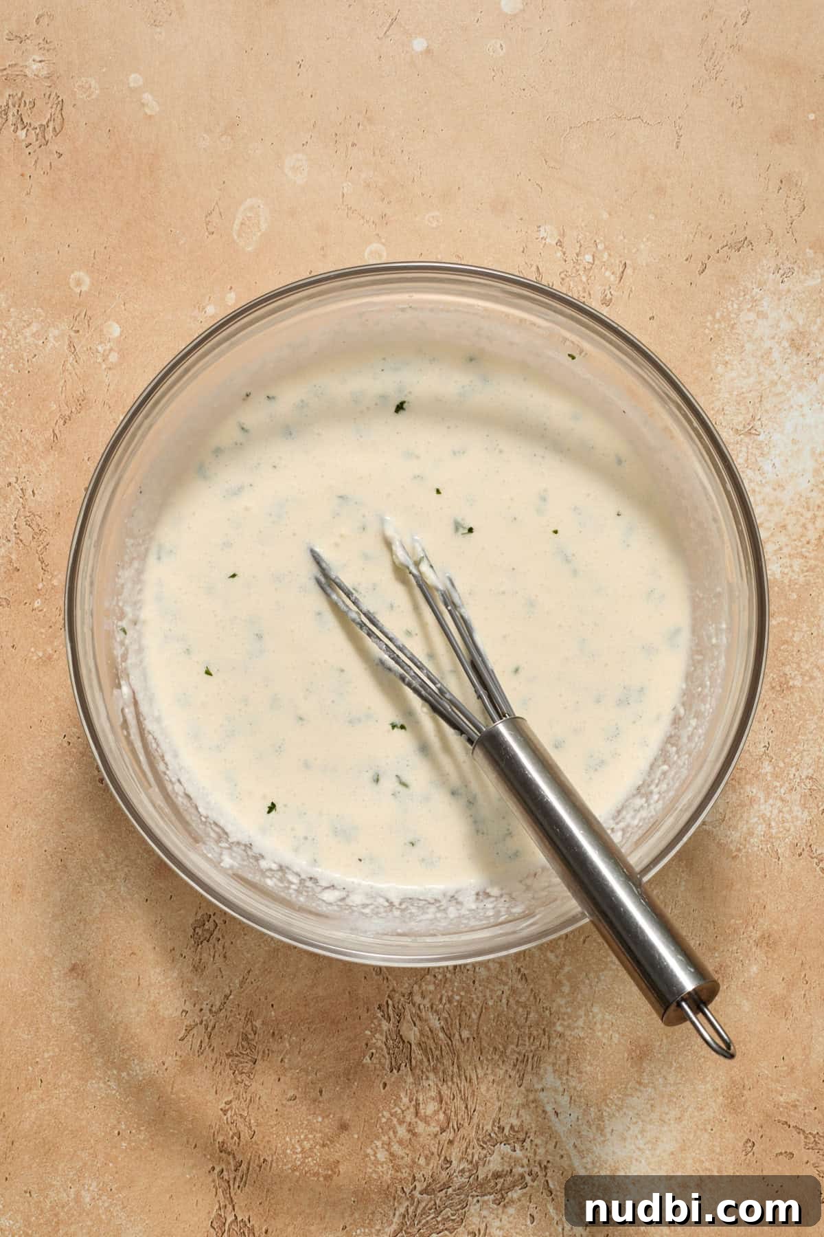 Creamy Slow Cooker Chicken Pasta Recipe 6 Creamy parmesan mixture in bowl with whisk.