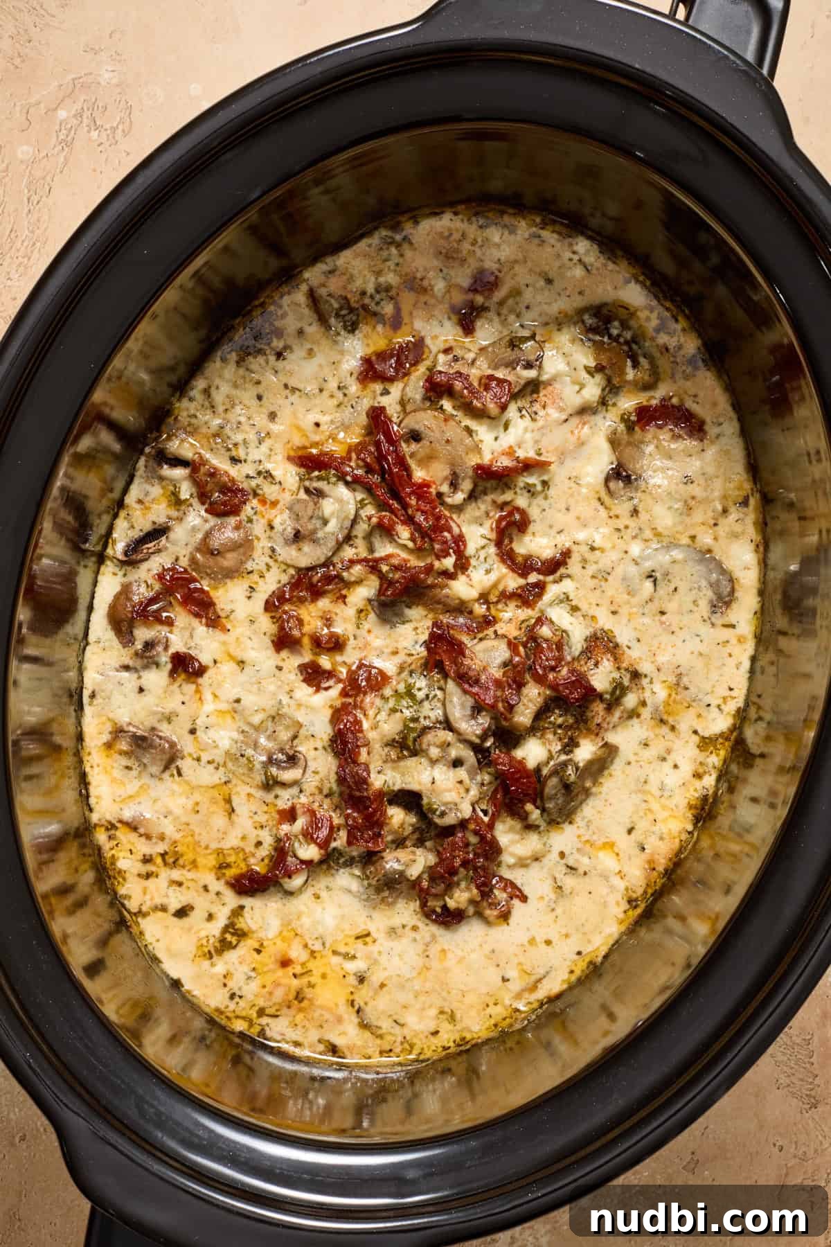 Creamy Slow Cooker Chicken Pasta Recipe 9 Cooked creamy chicken with mushrooms in crockpot.