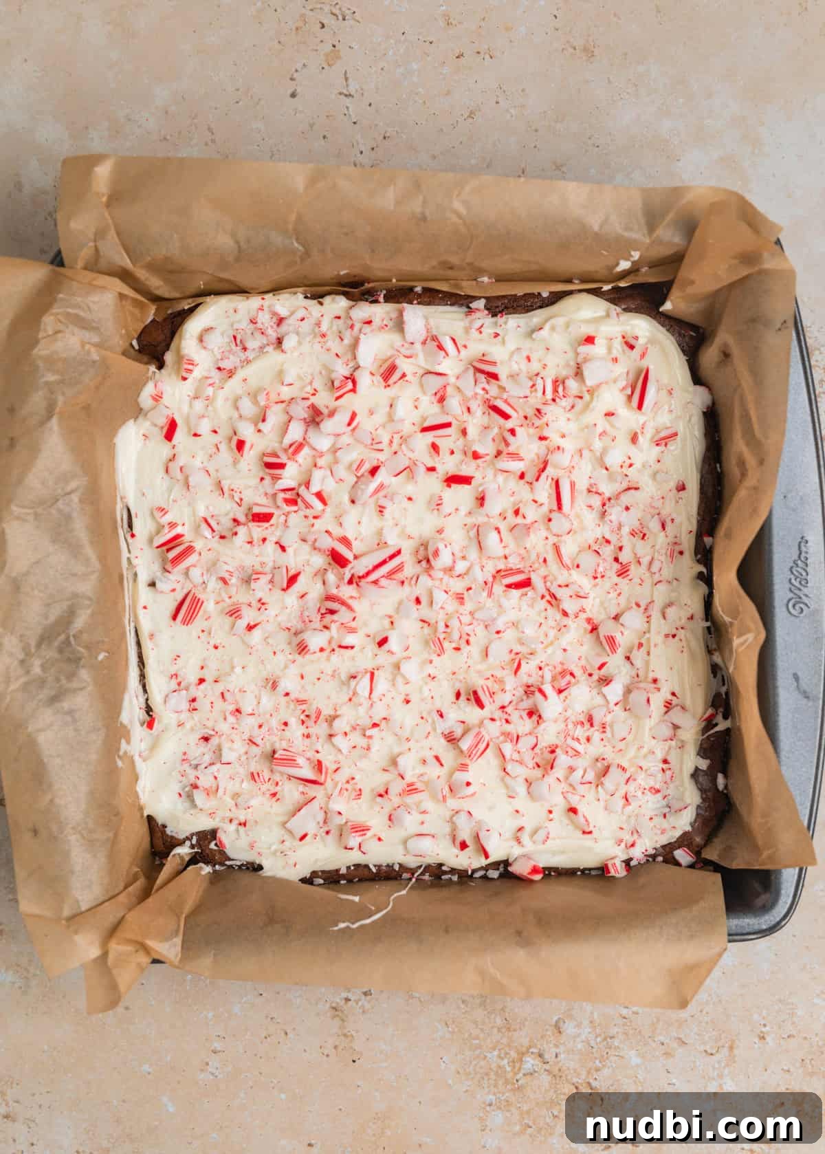 Peppermint Bark Brownies Recipe: Fudgy Chocolate Mint Bars 12 Crushed candy canes sprinkled over top of brownies covered in white chocolate.