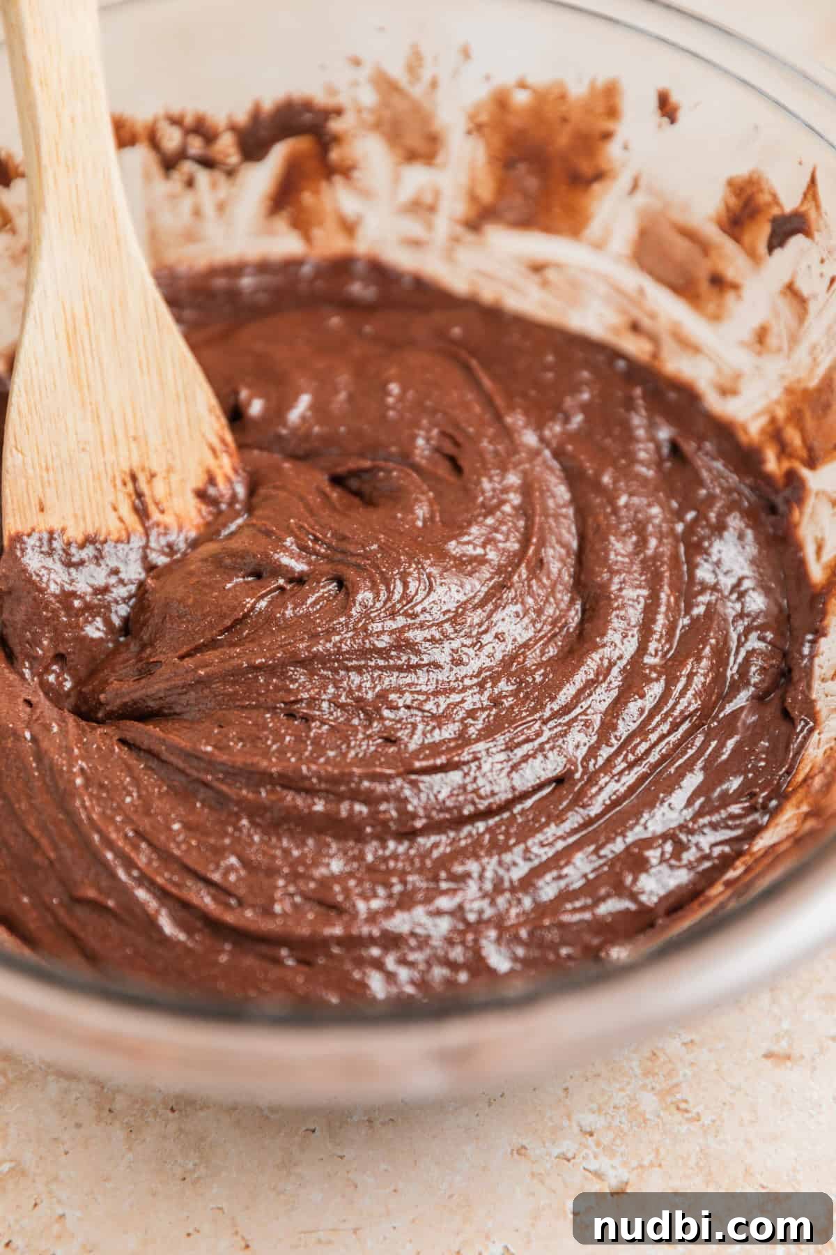 Peppermint Bark Brownies Recipe: Fudgy Chocolate Mint Bars 8 Brownie batter in glass bowl with wooden spoon.