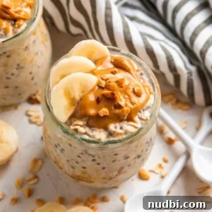 Glass jar with overnight oats topped with sliced banana and topped with peanut butter.