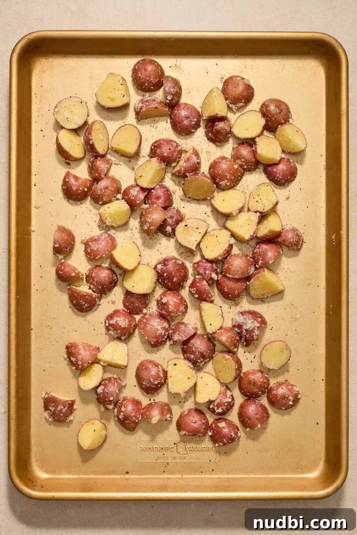Crispy Sheet Pan Pork Chops with Roasted Vegetables 6 Red potatoes spread on sheet pan.