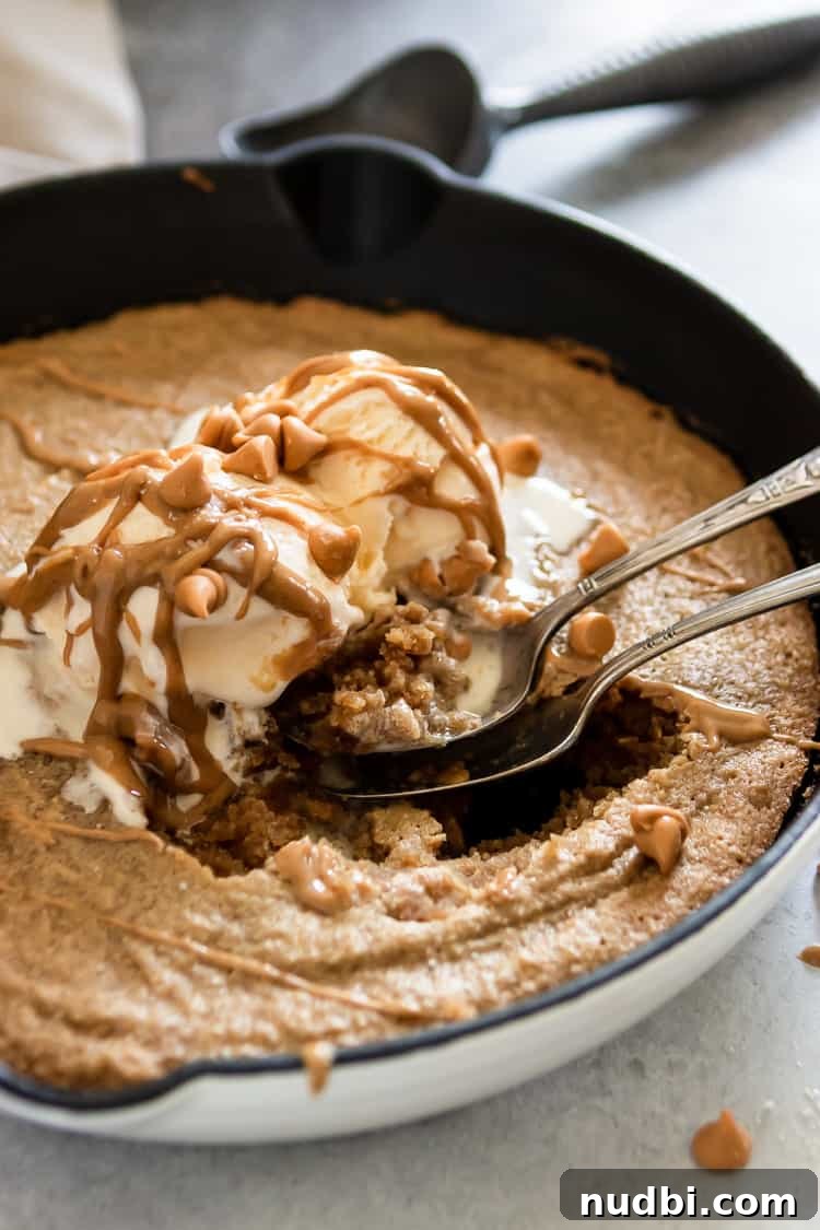 Salted Peanut Butter Skillet Cookie — Gluten Free Recipe 2 Skillet with cookie and spoons and peanut butter drizzle over ice cream.