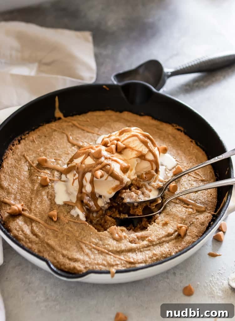Salted Peanut Butter Skillet Cookie — Gluten Free Recipe 3 Spoons in cookie with melting ice cream.