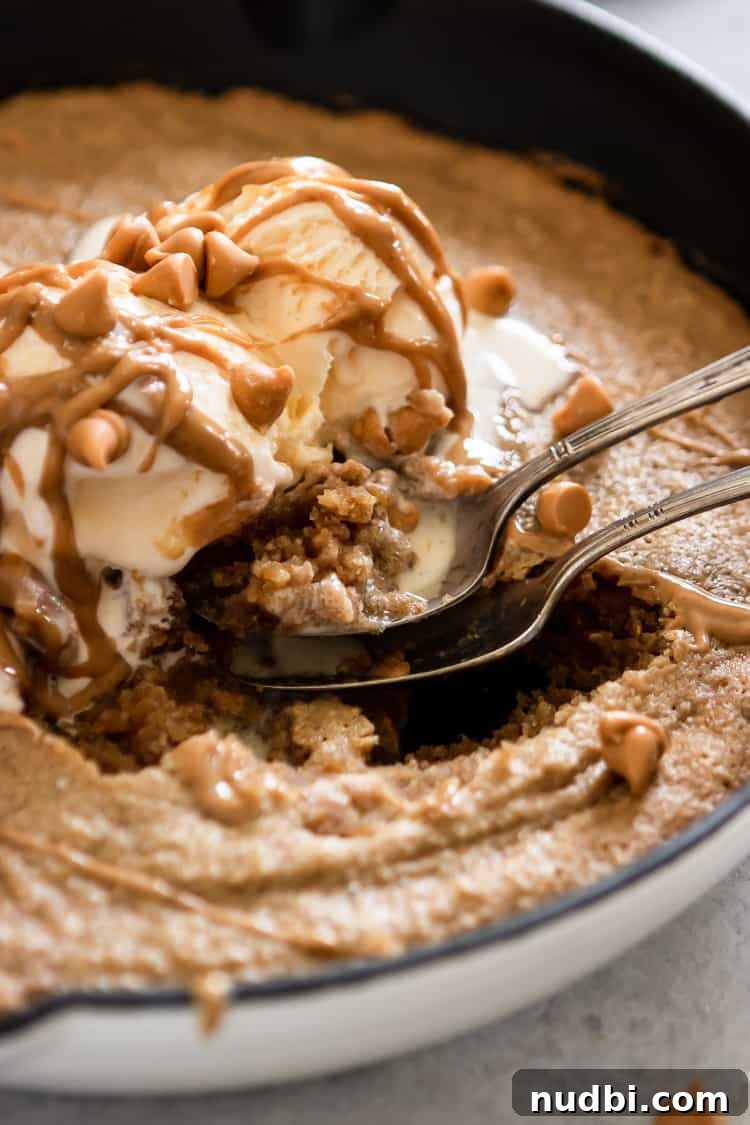 Salted Peanut Butter Skillet Cookie — Gluten Free Recipe 4 Spoons in skillet cookie with ice cream and peanut butter drizzle.