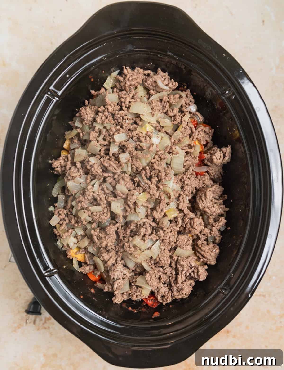 Slow Cooker Hamburger Soup Recipe for Hearty Weeknight Meals 4 Ground beef added to crockpot with hamburger soup ingredients before cooking.