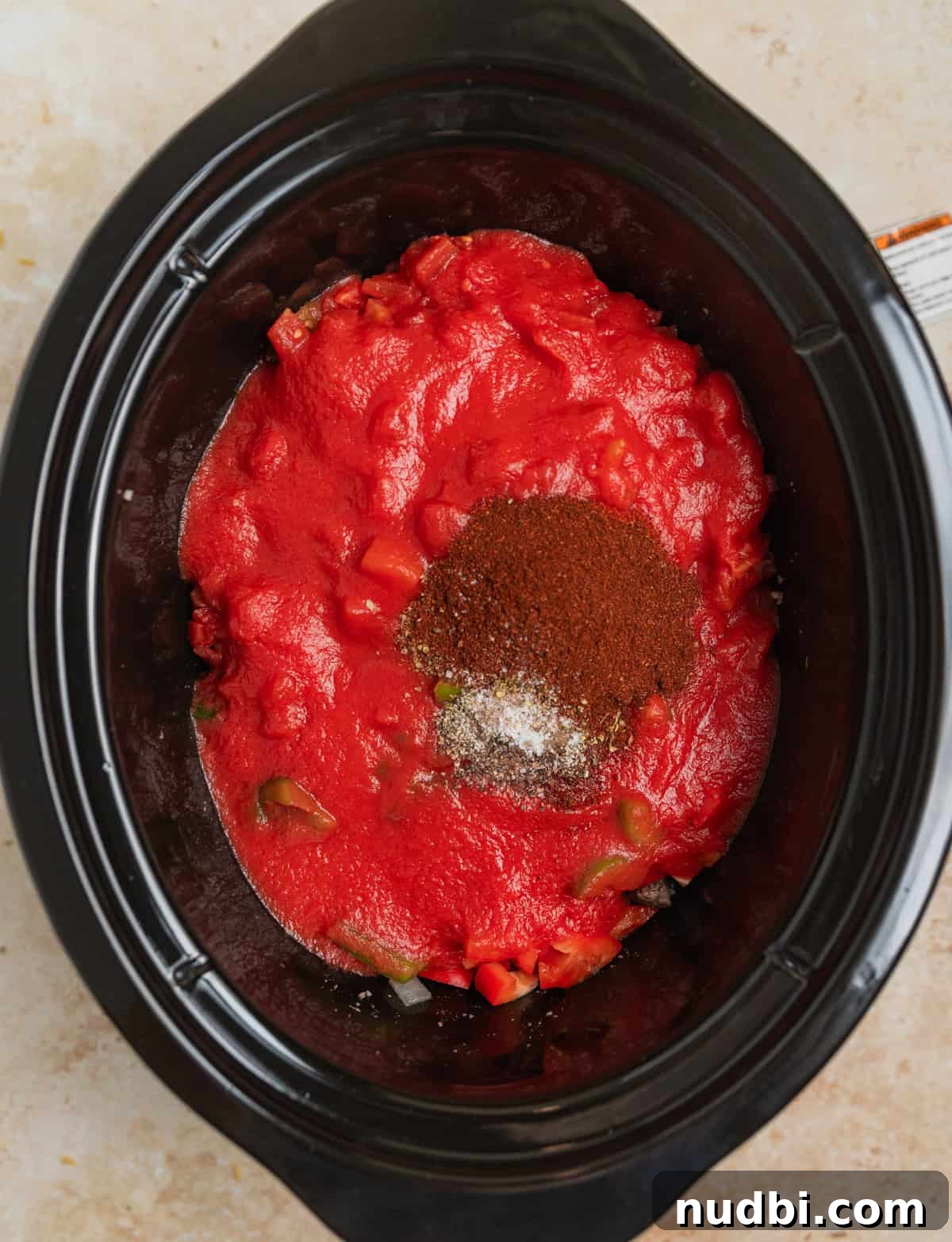Hearty No-Bean Slow Cooker Chili Recipe 5 Tomatoes, tomato sauce and seasoning in slow cooker before cooking.