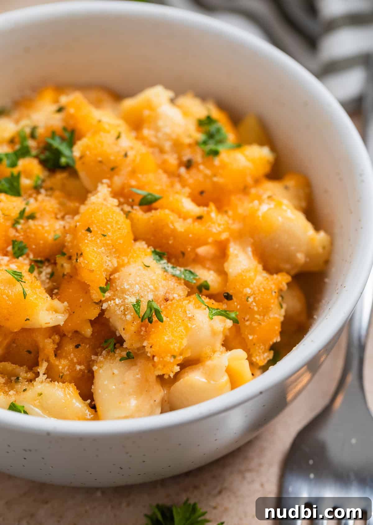 High-Protein Mac and Cheese Recipe for Muscle Gain 2 Protein macaroni and cheese in bowl topped with toasted breadcrumbs and parsley.