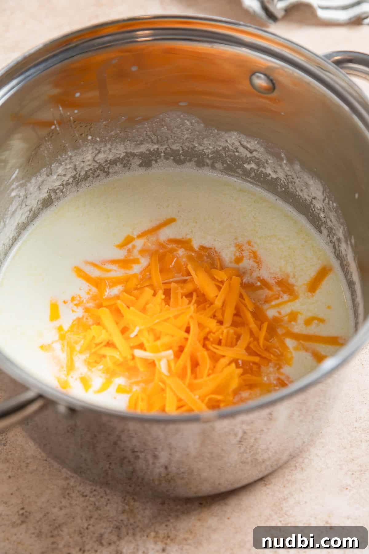 High-Protein Mac and Cheese Recipe for Muscle Gain 5 Greek yogurt, milk and shredded cheese in pot.