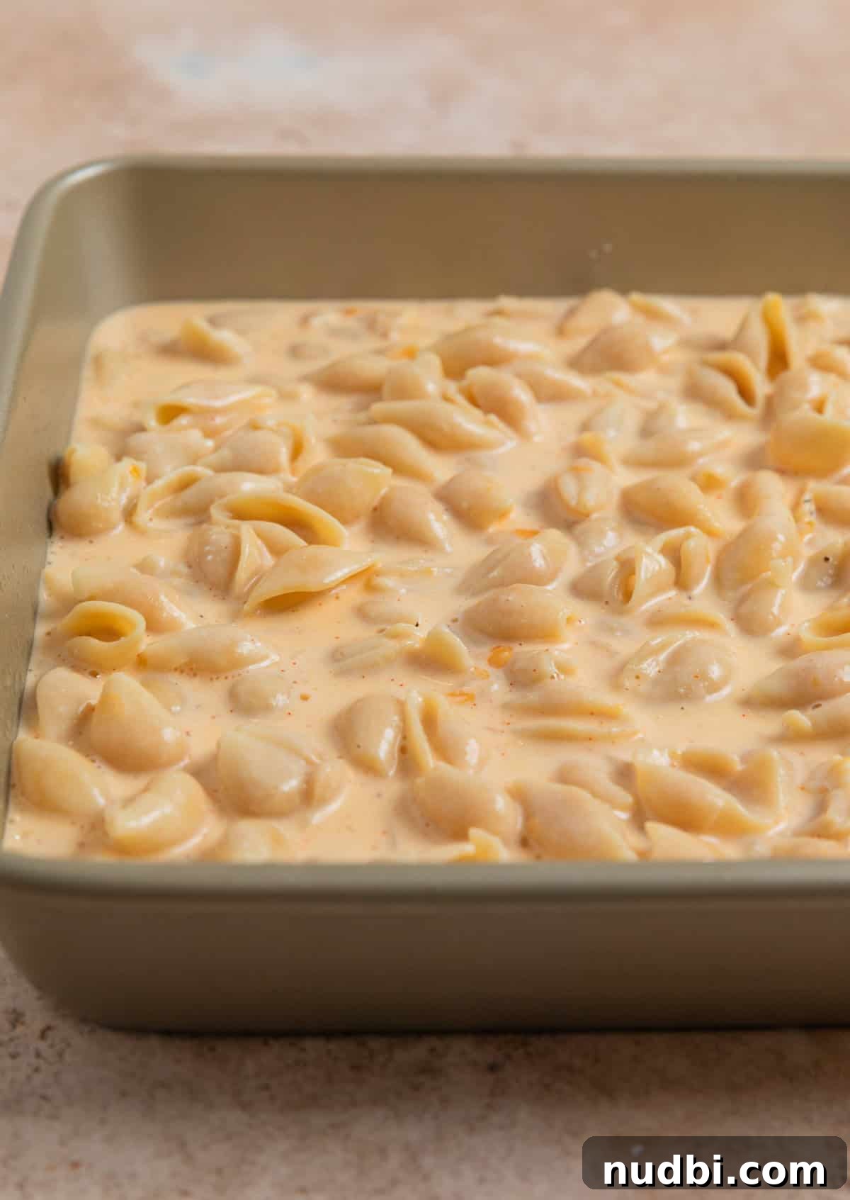 High-Protein Mac and Cheese Recipe for Muscle Gain 8 Protein macaroni and cheese mixture in square baking pan before baking.