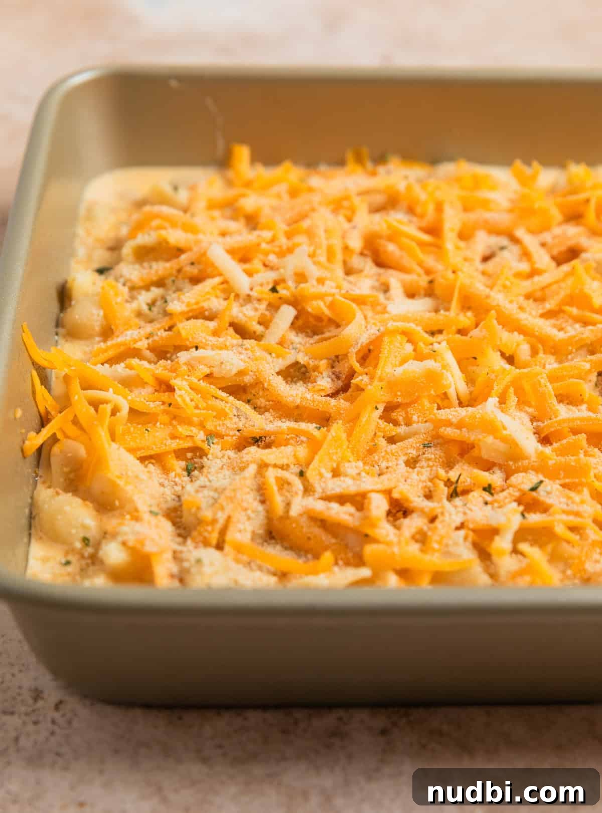 High-Protein Mac and Cheese Recipe for Muscle Gain 9 Shredded cheddar and white cheddar cheese on top of mac and cheese mixture.