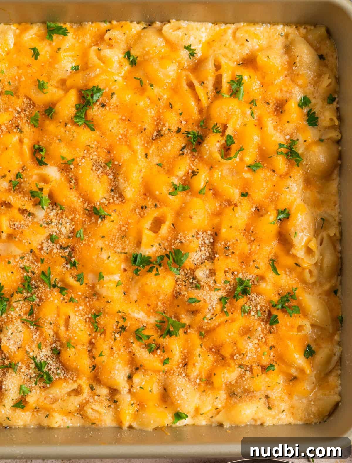 High-Protein Mac and Cheese Recipe for Muscle Gain 10 Pan with baked protein packed macaroni and cheese topped with breadcrumbs and chopped parsley.