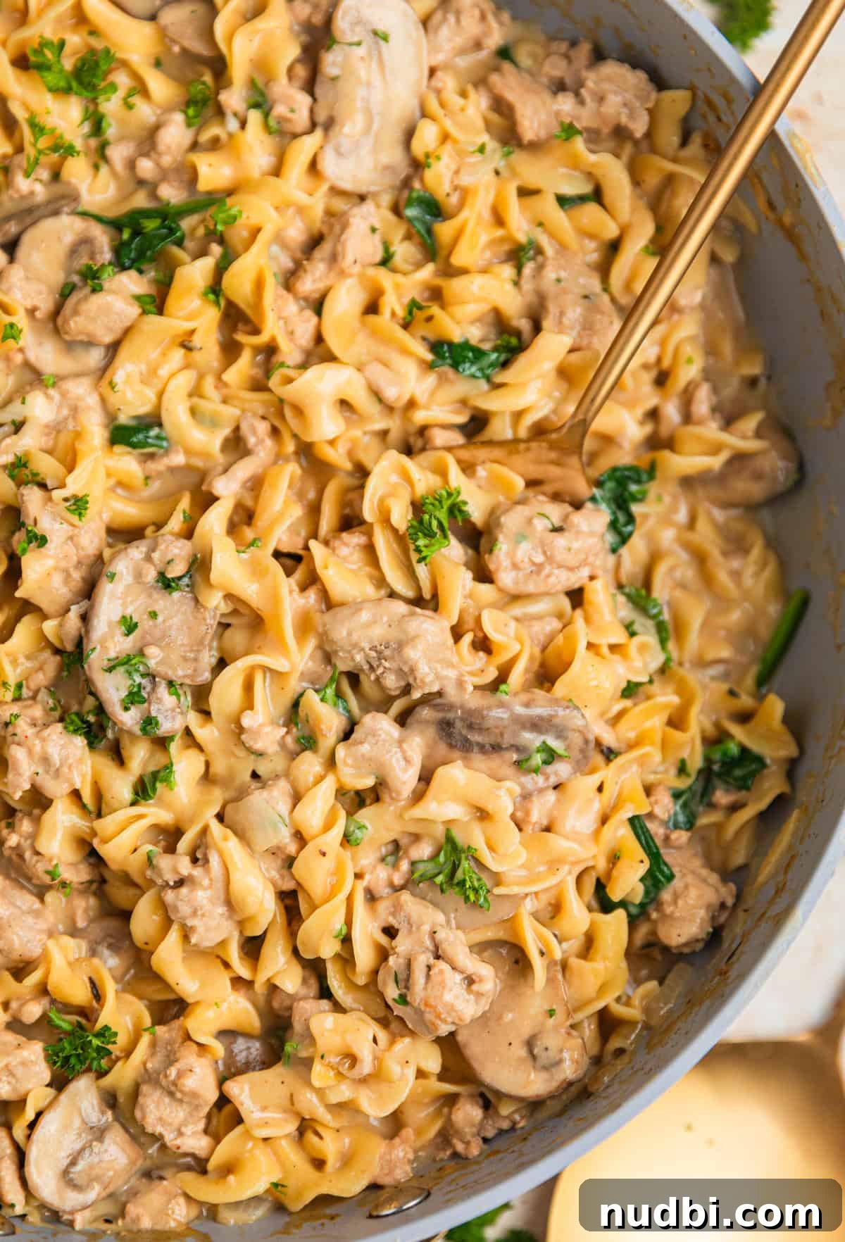 Creamy Ground Turkey Stroganoff Recipe for Weeknight Dinner 2 Skillet with ground turkey stroganoff with spoon scooping into the dish.
