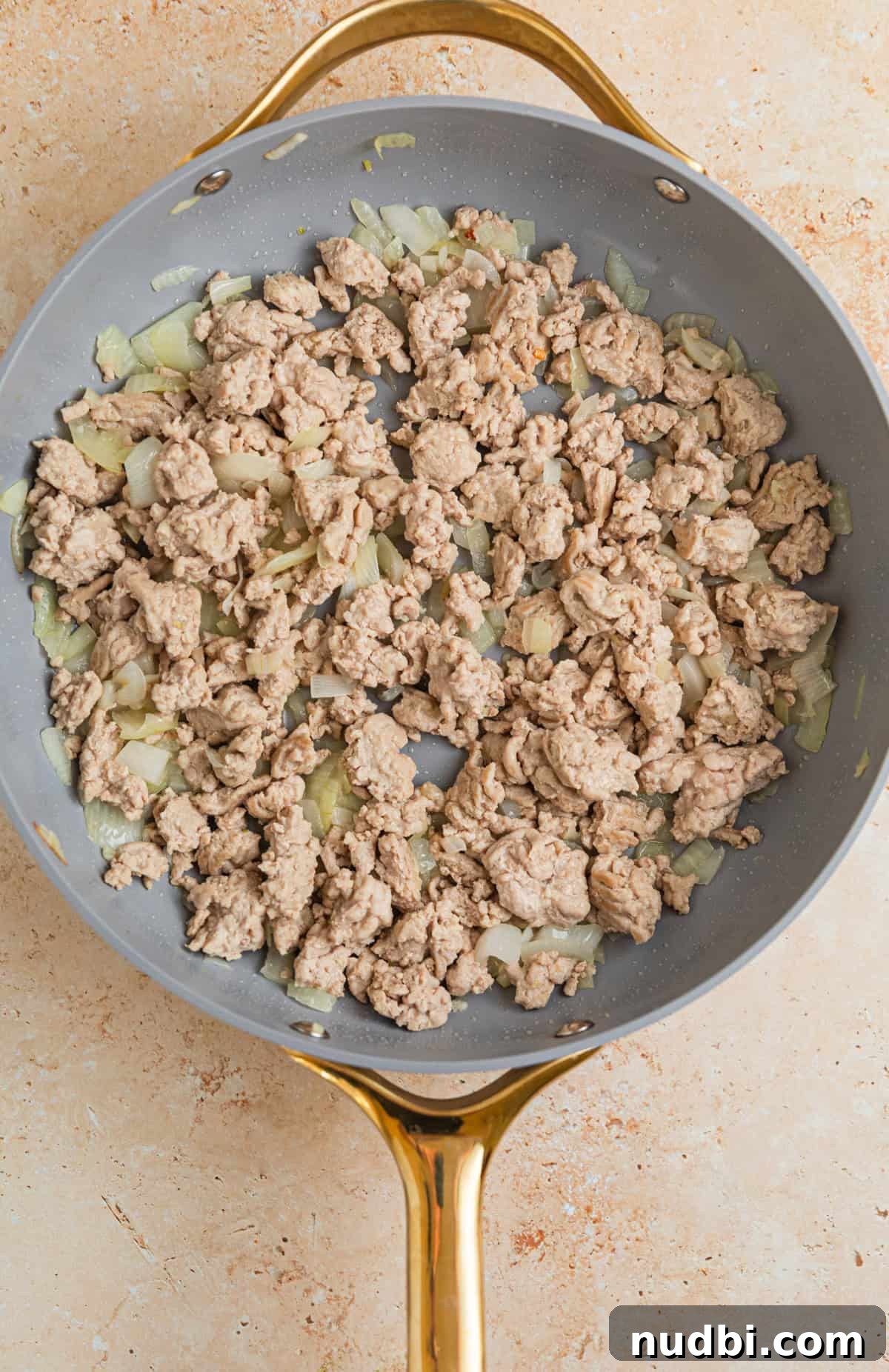 Creamy Ground Turkey Stroganoff Recipe for Weeknight Dinner 5 Ground turkey browned in skillet with onions and garlic.