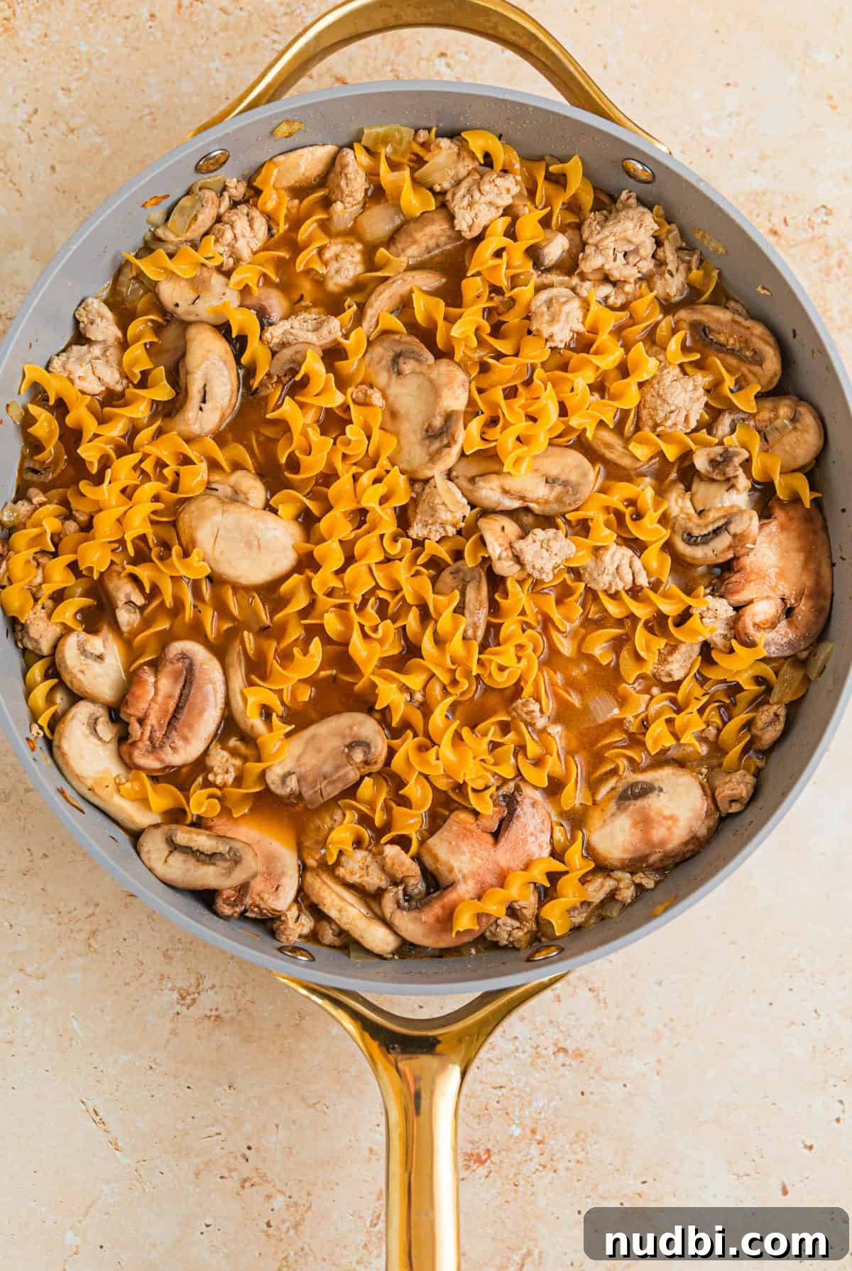 Creamy Ground Turkey Stroganoff Recipe for Weeknight Dinner 7 Broth and egg noodles added to skillet with meat and onions.