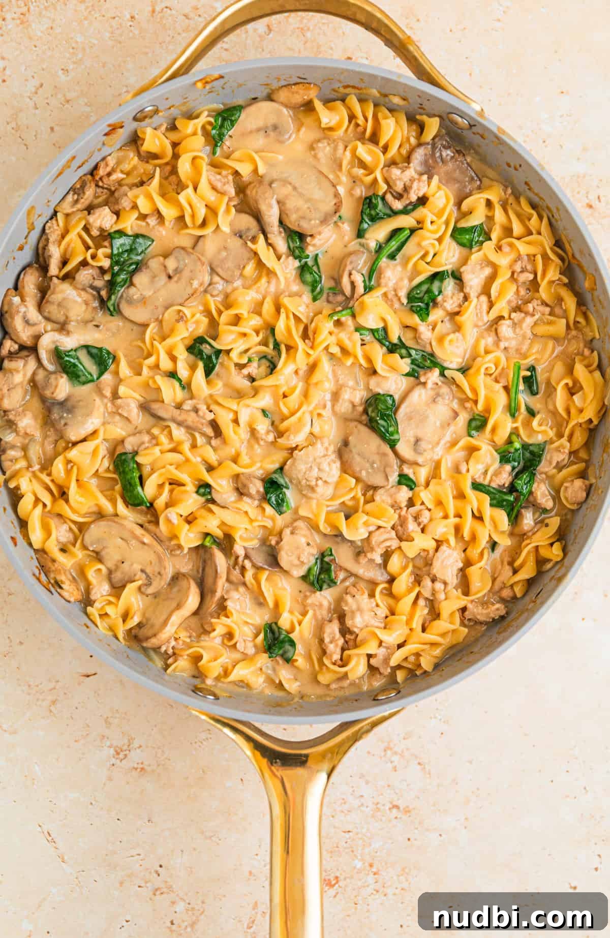 Creamy Ground Turkey Stroganoff Recipe for Weeknight Dinner 9 Cream cheese, sour cream and spinach added to skillet with turkey stroganoff ingredients.