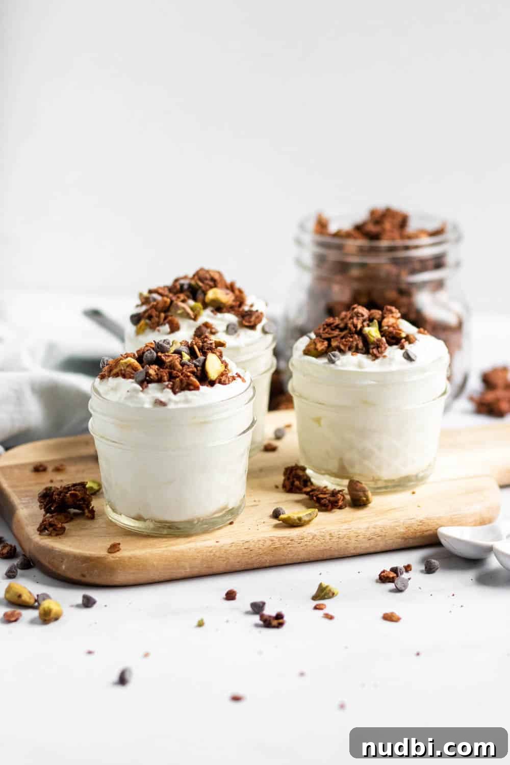 Chocolate Pistachio Granola with Sea Salt — Crunchy Homemade Recipe 3 Chocolate granola with chocolate chips and pistachios on yogurt in jars.