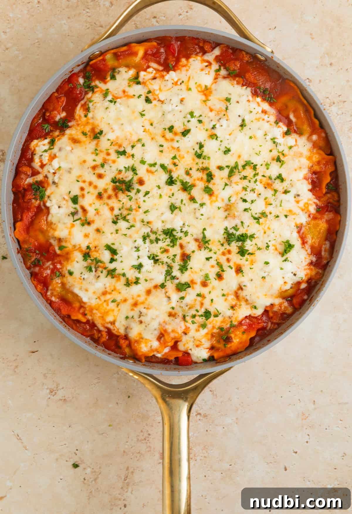 Skillet Ravioli Lasagna Recipe: Quick One-Pan Italian Dinner 11 Skillet ravioli lasagna with cheese melted on top and parsley added.