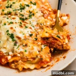 Skillet Ravioli Lasagna Recipe: Quick One-Pan Italian Dinner 16 Skillet lasagna made with ravioli on plate with fork scooping up a forkful.