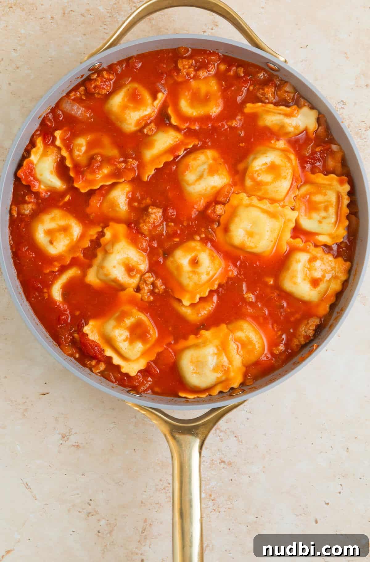 Skillet Ravioli Lasagna Recipe: Quick One-Pan Italian Dinner 8 Lasagna added to skillet with meat and tomato sauce.