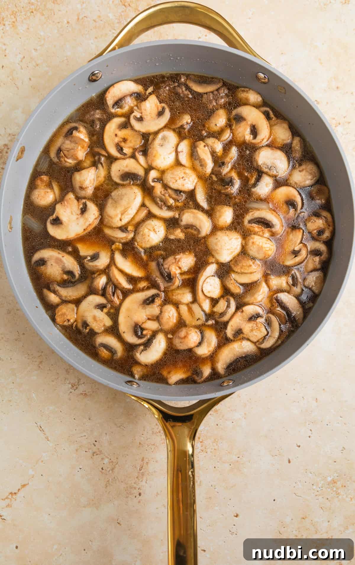 Creamy One-Pot Ground Beef Stroganoff Recipe 6 Broth added to skillet with beef and mushrooms.