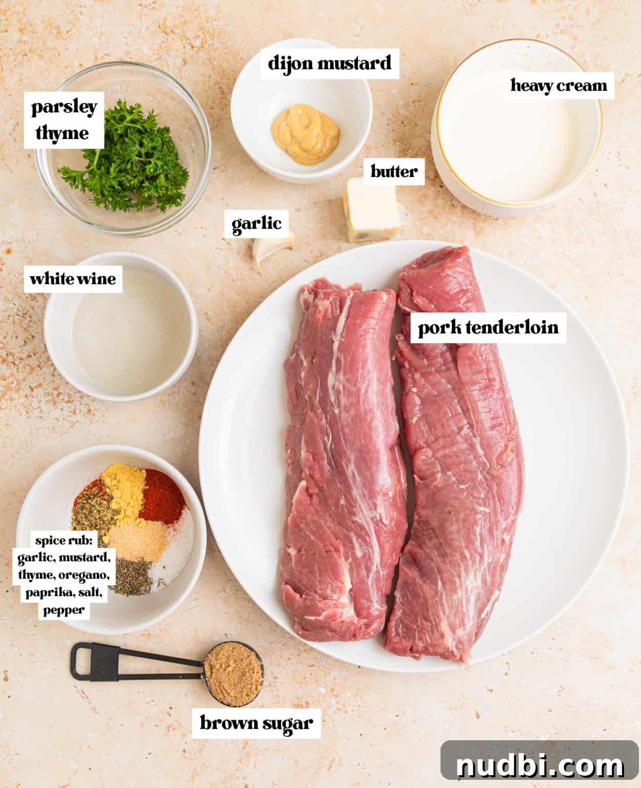 Juicy Pork Tenderloin with Creamy Mustard Sauce receta 3 Pork tenderloin on plate, cream, herbs, butter, spices and other ingredients arranged on surface with labels.