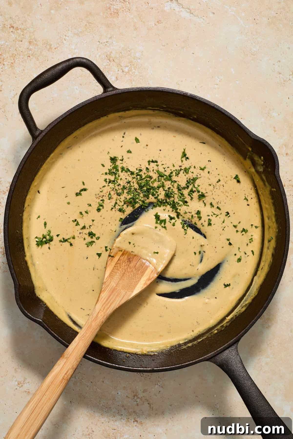 Juicy Pork Tenderloin with Creamy Mustard Sauce receta 9 Creamy mustard sauce in skillet with parsley added in.