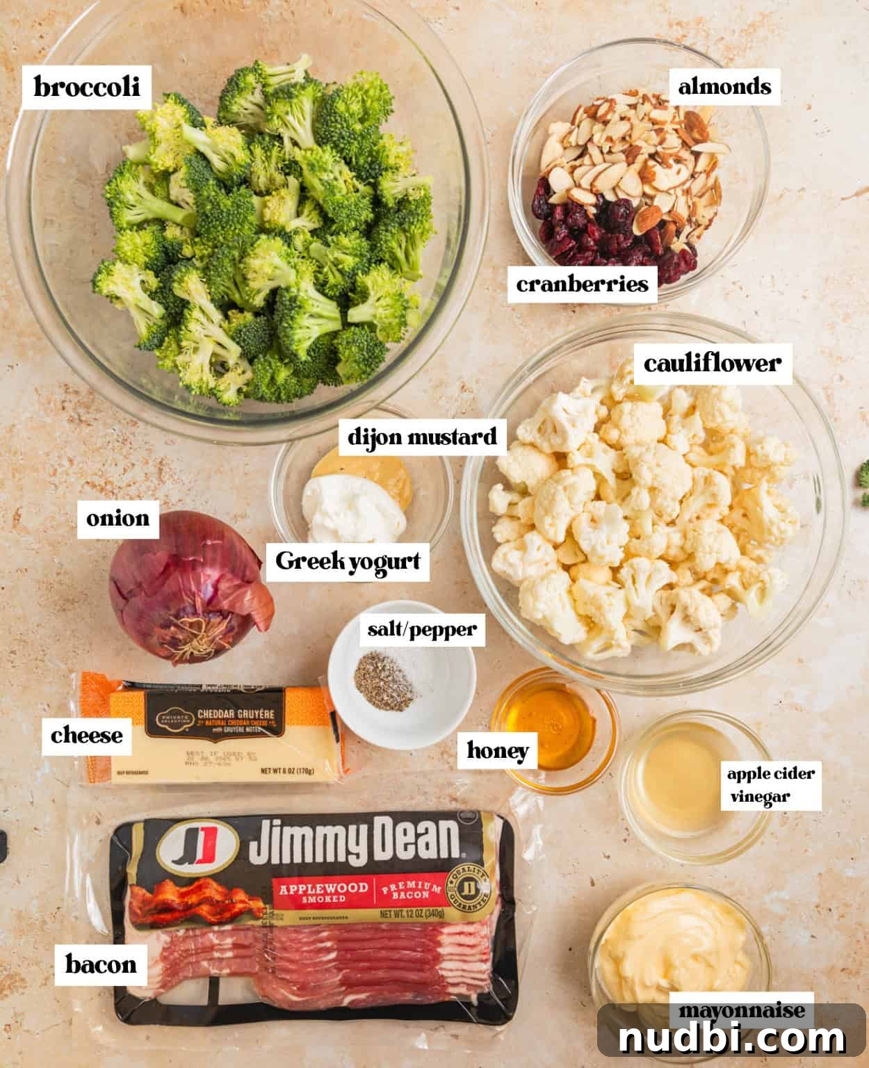 Crunchy Broccoli and Cauliflower Salad with Lemon-Dill Dressing 3 Bacon, mayo, almonds, broccoli florets, cauliflower and other ingredients for recipe arranged on surface with labels.
