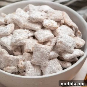 Snickerdoodle Puppy Chow Recipe — Cinnamon Sugar Snack Mix 7 Cinnamon puppy chow chex mix in white bowl.