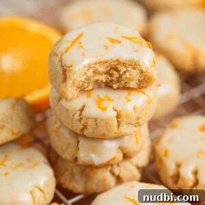 Almond Flour Orange Cookies Recipe — Light Citrus Cookie Guide 11 Stack of gluten free almond flour cookies with bite taken out of top cookie.